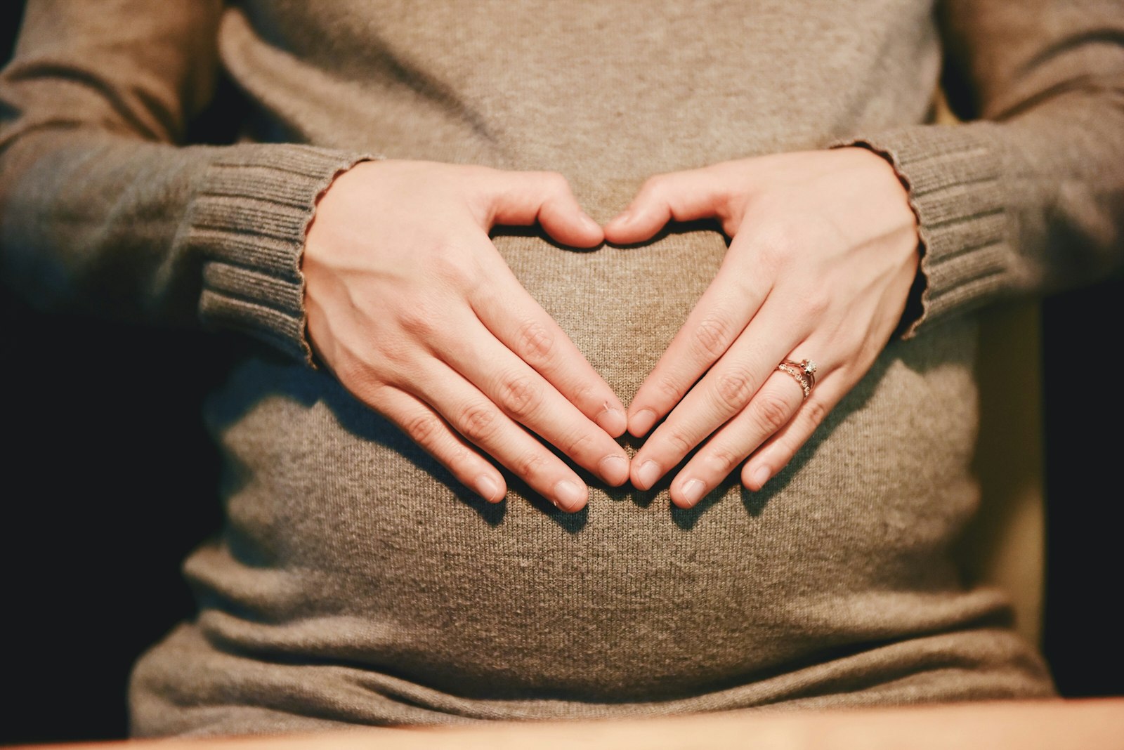 Pregnant woman holding her belly A pregnant woman holds her hands on her belly