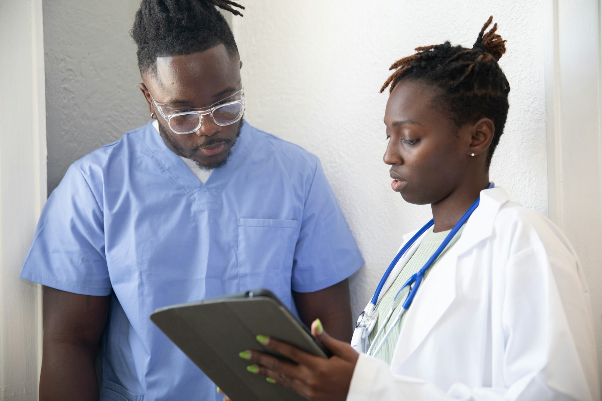 photo-1666886573553-6548db92db79 A doctor shows a patient something on a tablet during a consultation.