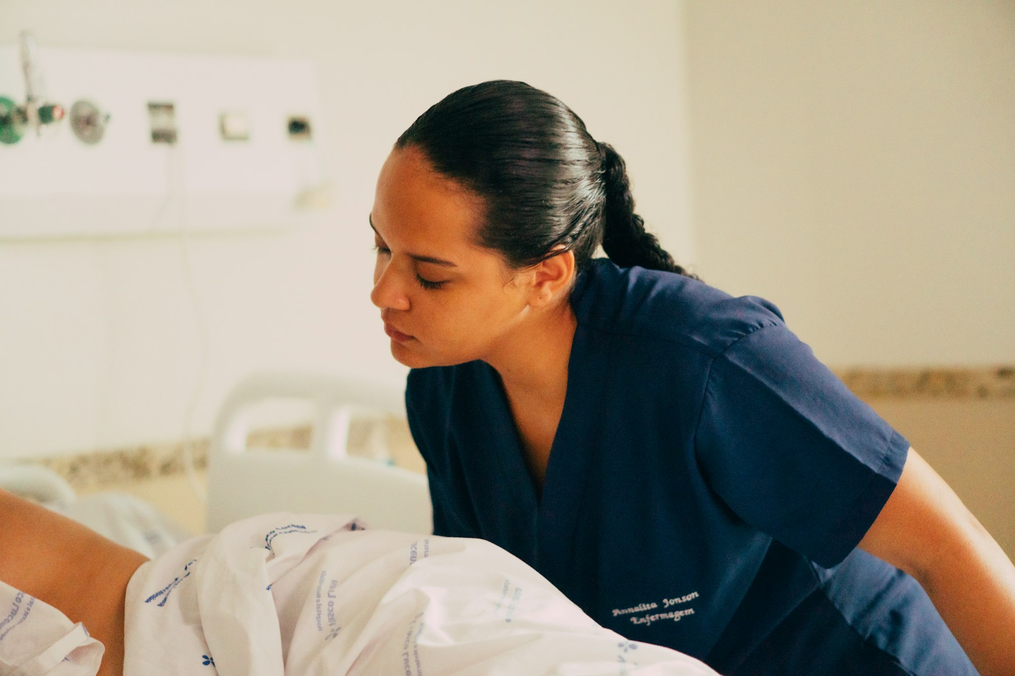 photo-1749065312519-1902cb8431ae A nurse attends to a patient in a hospital.