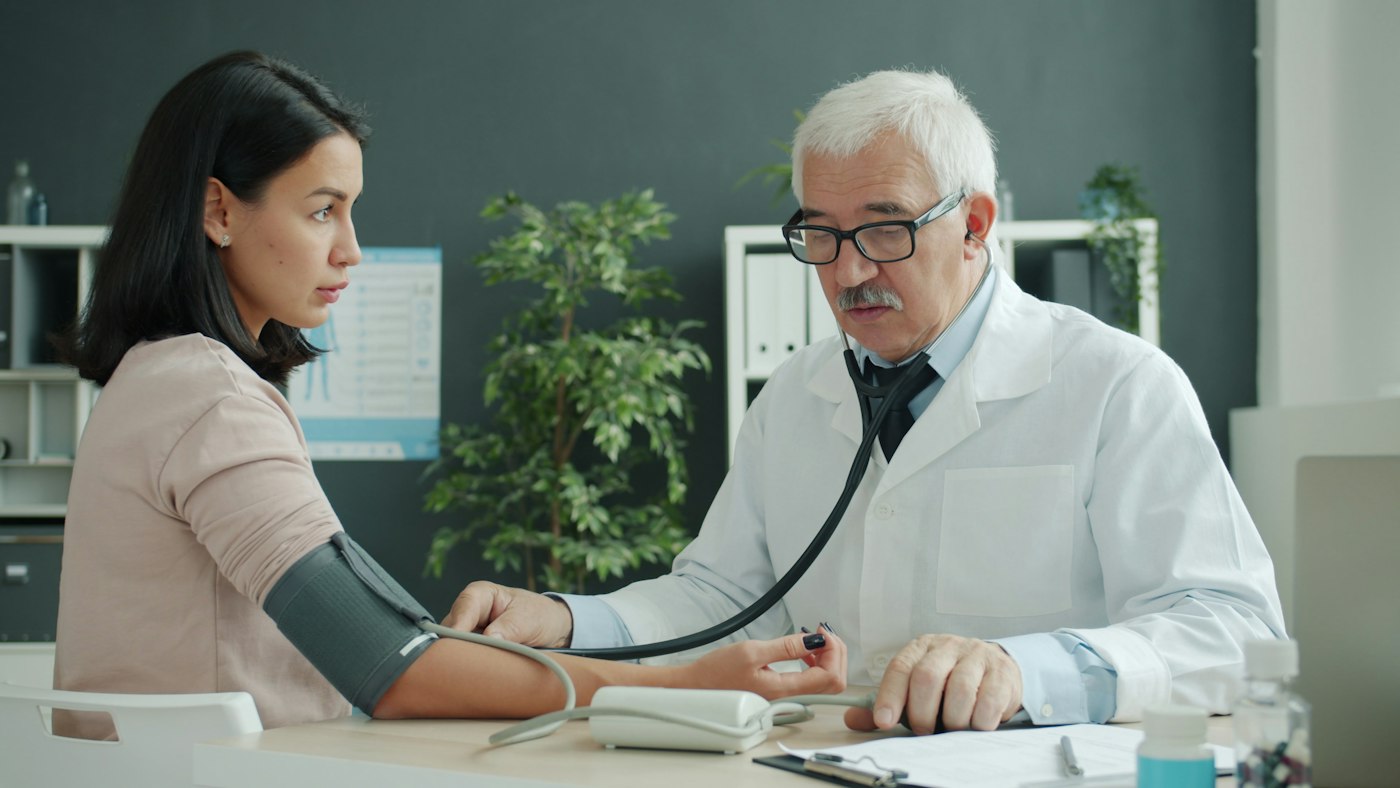 Blood pressure check A doctor checks a young woman's blood pressure during a medical appointment
